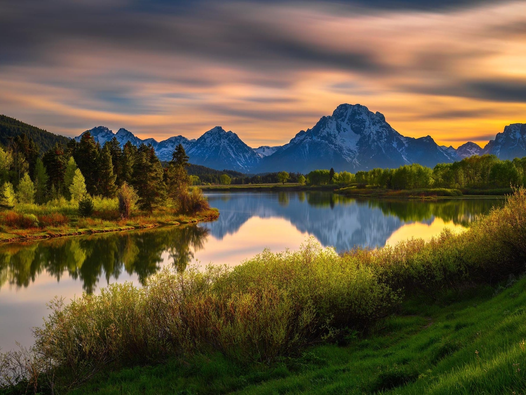 Sunrise over mountains reflected on a calm lake